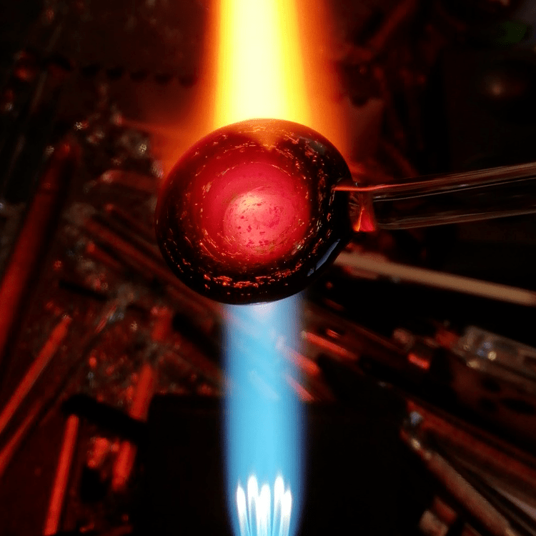 Lampwork pendant in the flame being made, glass blowing in action using solid pyrex glass and dichoic glass to make unique jewellery